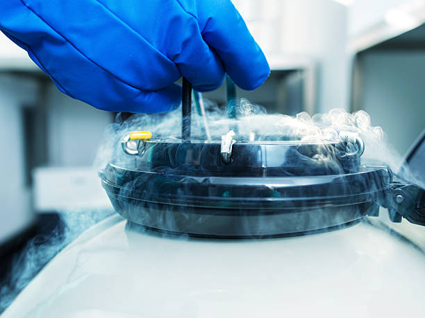 816c5766-3d17-4741-979b-b1941e6339ab Gloved hand turning a valve on a steam autoclave with steam escaping from the lid.